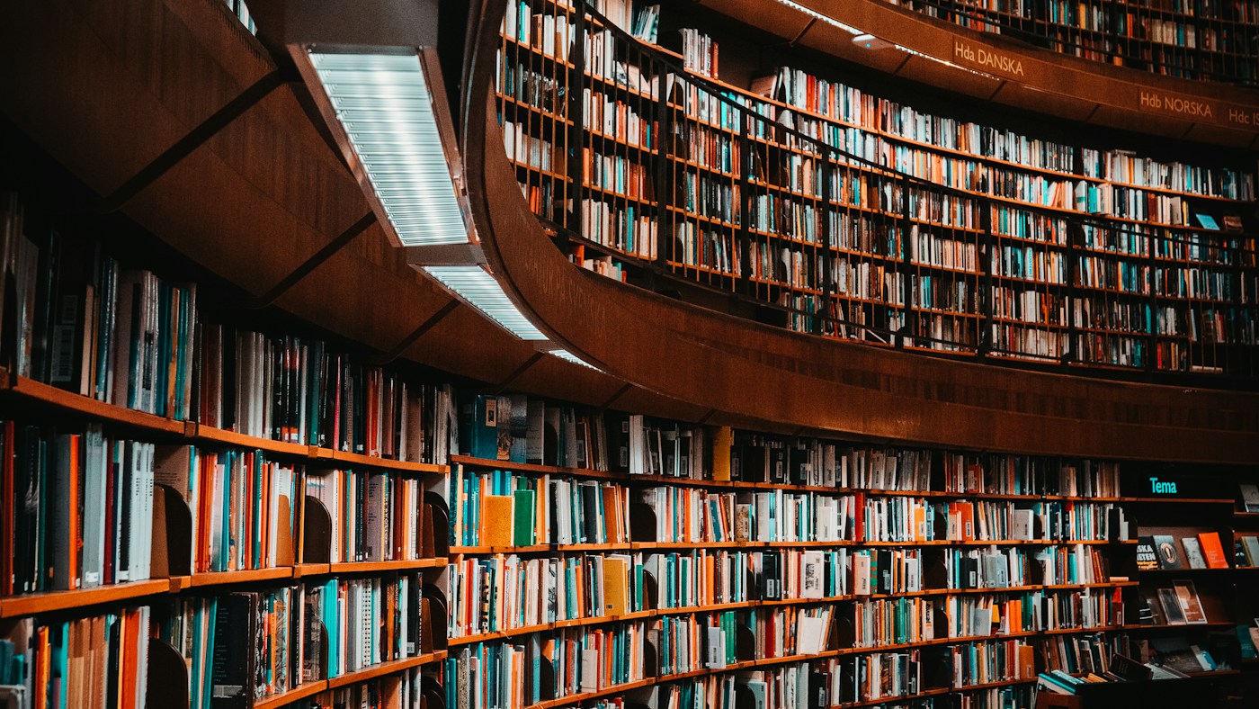 Curved wooden library shelves filled with books.